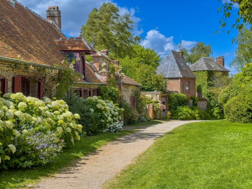 L'hôtel Le Cardinal à Poix, France : de charmants cottages en brique avec hortensias blancs et jardins soignés en bordure de route de campagne