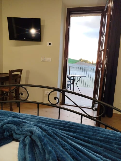 Bedroom at Agriturismo Marinello in Pienza with garden view, flat-screen TV, and direct patio access with countryside