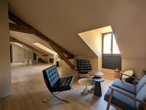 Salon moderne au dernier étage du Domaine Alga B&B à Bourg-Charente avec chaises noires et poutres en bois