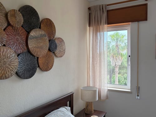 Quarto aconchegante em Quinta Vale da Paz, Azambuja com pratos decorativos na parede, vista de palmeira pela janela e luminária de cabeceira.