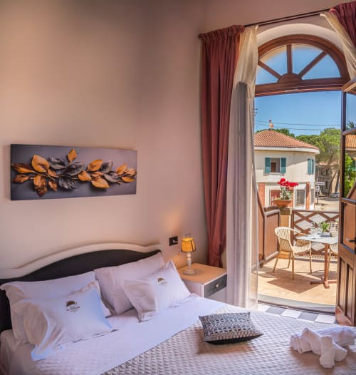 Deluxe double room at Albergo Al Cinghiale with balcony overlooking Guspini countryside, modern décor, and terracotta-tiled