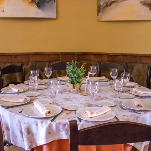 Mesa de comedor elegantemente preparada en Hotel Balcón De Los Montés en Colmenar con mantel de mármol y decoración verde