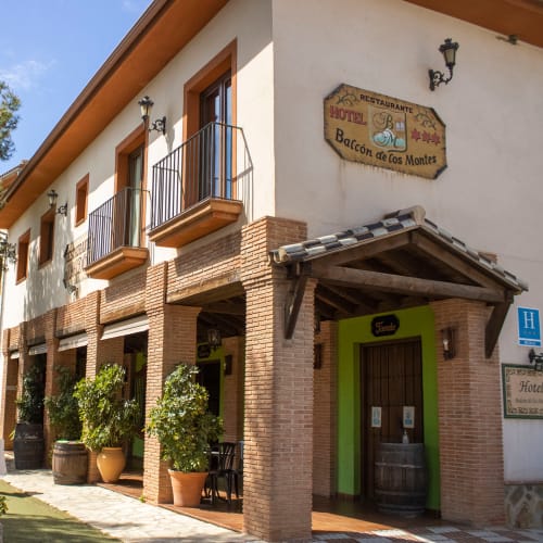 Hotel Balcón de los Montes en Colmenar con arquitectura de ladrillo, entrada verde, balcones y terraza restaurante.