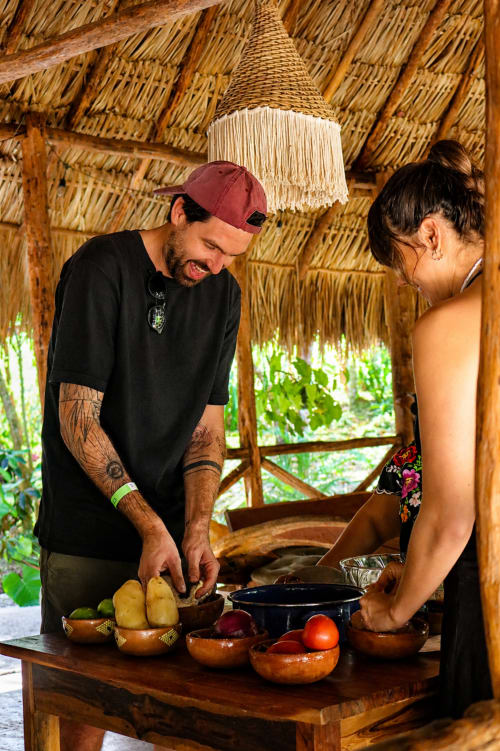 Chef preparando verduras frescas en la cocina palapa del Hotel Boutique Cenote Secreto Maya, Valladolid Yucatán.