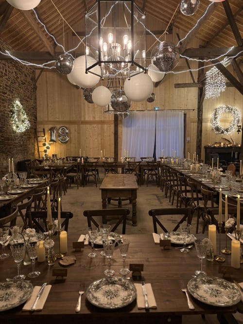 Salle de réception élégante du Domaine du Tertre Ychot avec tables décorées, lustres et éclairage festif pour événements à Dol