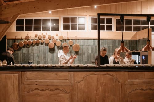 Démonstration culinaire en cuisine moderne à la salle de réception du Domaine du Tertre Ychot, Dol de Bretagne, avec casseroles en cuivre et luminaire suspendu