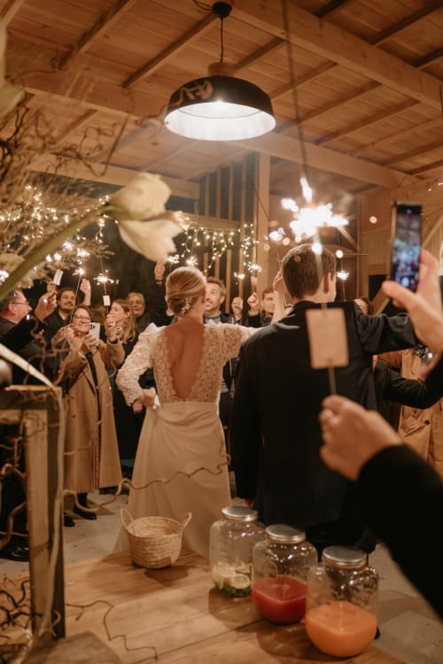 Invités de mariage avec des cierges magiques dans l'élégante salle de réception du Domaine du Tertre Ychot, Dol-de-Bretagne