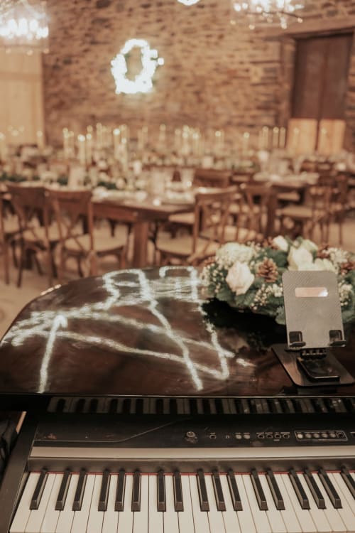 Mise en place élégante pour réception de mariage au Domaine du Tertre Ychot avec piano, compositions florales et tables aux chandelles