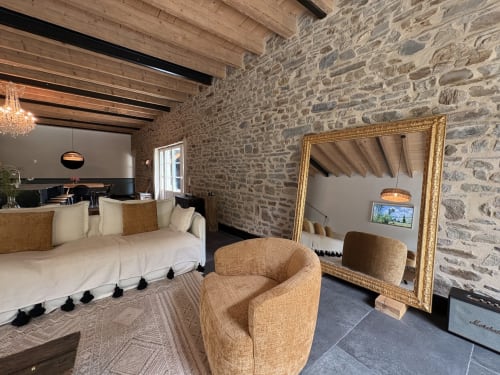 Suite en pierre luxueuse au Domaine du Tertre Ychot avec lit, fauteuil et miroir doré à Dol de Bretagne