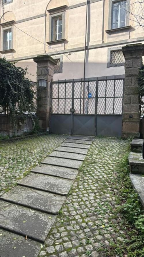 Ingresso della corte di Il Giardinetto di Elelú B&B a Orvieto con sentiero in pietra e cancello in ferro