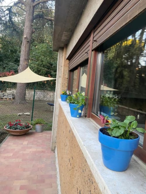 Giardino del patio a Il Giardinetto di Elelú a Orvieto con piante in vaso, veli d'ombra e area relax