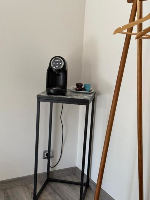 Caffettiera nera su tavolo metallico con tazze presso Il Giardinetto di Elelú B&B a Orvieto, Italia