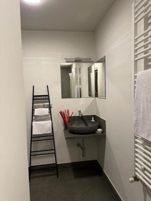 Bagno moderno nell'appartamento Il Giardinetto di Elelú B&B, Orvieto, con lavabo rotondo nero, specchio, scaldasalviette e