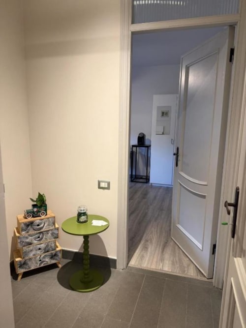 Accogliente ingresso del B&B Il Giardinetto di Elelú a Orvieto con tavolo verde, pianta in vaso e moderne porte bianche