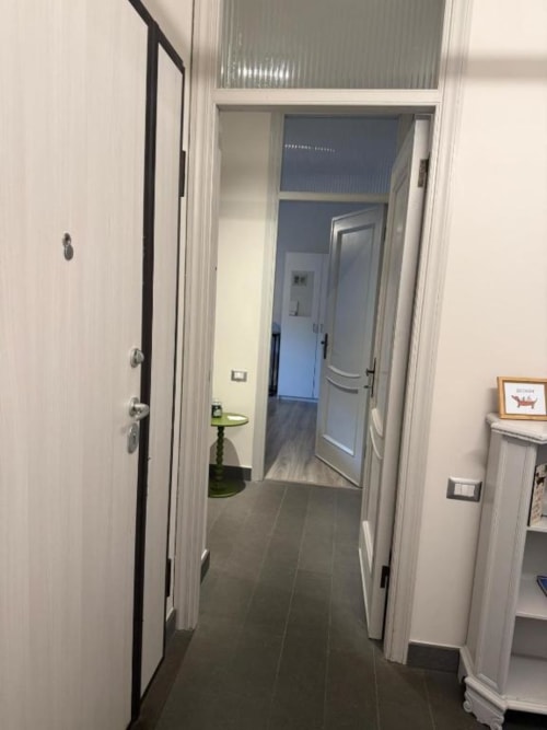 Corridoio moderno all'Il Giardinetto di Elelú B&B di Orvieto con pareti bianche, pavimentazione in piastrelle e porte che conducono alle camere
