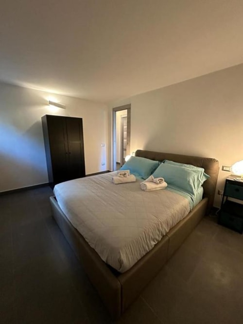 Camera moderna della B&B di Orvieto con letto matrimoniale, guardaroba nero, cuscini verdi e porta del bagno en-suite