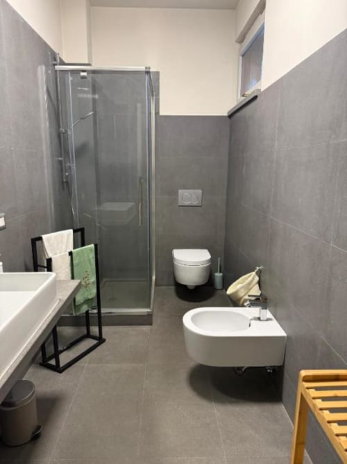 Bagno moderno all'Il Giardinetto di Elelú a Orvieto con piastrelle grigie, doccia walk-in, lavabo e wc bianchi
