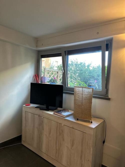 Moderno spazio di lavoro in appartamento con TV a schermo piatto su mobile in legno, vista giardino dalle ampie finestre, Il Giardinetto di