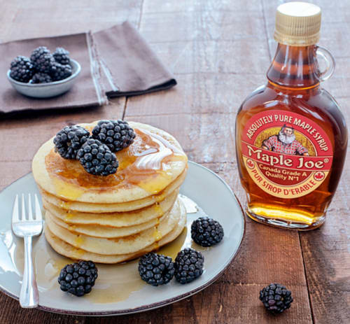 Stack of fluffy pancakes topped with blackberries and maple syrup, served at Clos Céleste B&B in Normandy