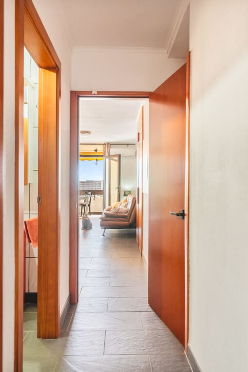 Pasillo con puertas de madera que conducen a apartamento con vista al mar en Home Stay Gran Canaria, San Bartolomé de Tirajana
