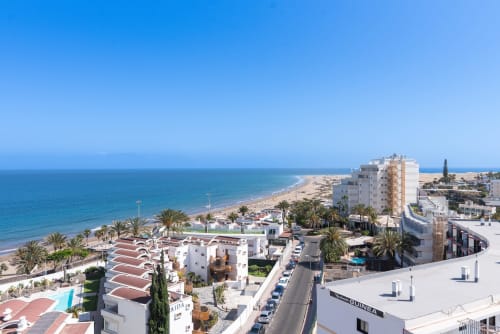 Edificio de apartamentos frente al mar en San Bartolomé de Tirajana con vistas al océano, palmeras y playa de arena Las Arenas, Gran