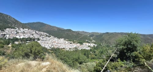 Pueblecito blanco en la cima de la colina de Ojén rodeado de montañas verdes cerca de Marbella, España