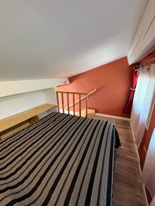 Chambre ocre avec literie rayée au gîte Le Romulus à Roumoules, France