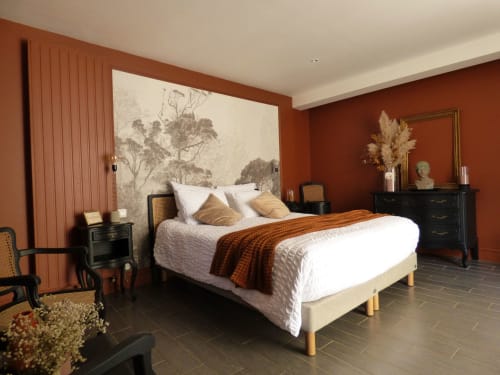 Élégante chambre double aux Rives De La Tronne avec murs rouille, literie blanche, mobilier noir et tête de lit décorée d'art botanique