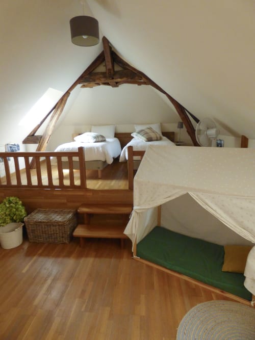 Attic bedroom with wooden beam frame, twin beds, cream canopy, hardwood floors at Les Rives De La Tronne, Mer France
