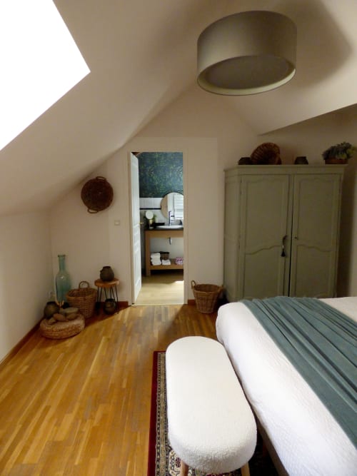 Spacious attic bedroom at Les Rives De La Tronne with wooden floor, bed, wardrobe, and ensuite bathroom access