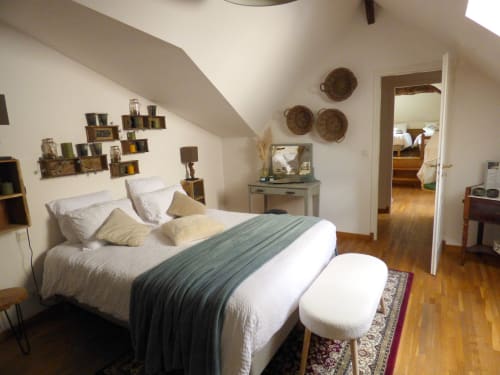 Bright duplex bedroom with white bedding, wooden floor, and decorative wall baskets at Les Rives De La Tronne, Mer