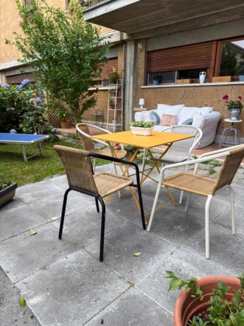 Terrazza del giardino con tavolo da pranzo giallo, sedie intrecciate e zona lounge a Il Giardinetto di Elelú a Orvieto