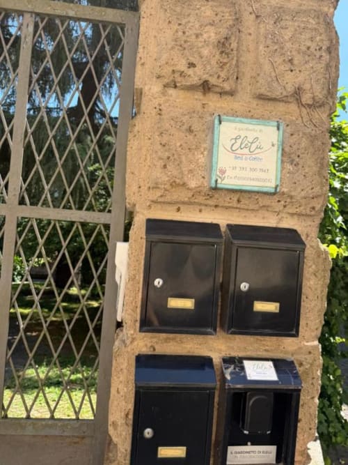Ingresso al B&B Il Giardinetto di Elelú a Orvieto con cassette postali e porta verde in metallo