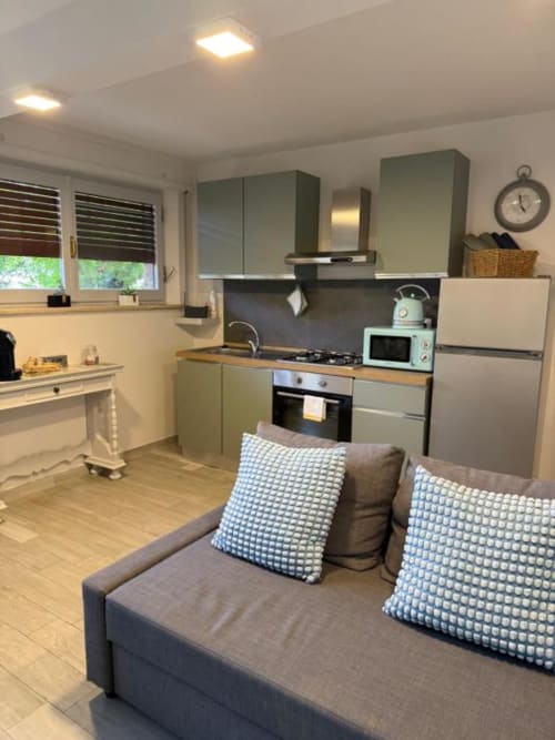 Cucina moderna e zona living nell'Appartamento Superior a Due Camere da Letto presso Il Giardinetto di Elelú a Orvieto con mobili salvia