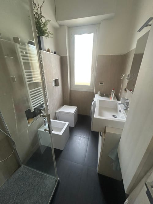 Bagno moderno presso la Luan House B&B di Genova con doccia, wc, lavabo e pavimentazione scura