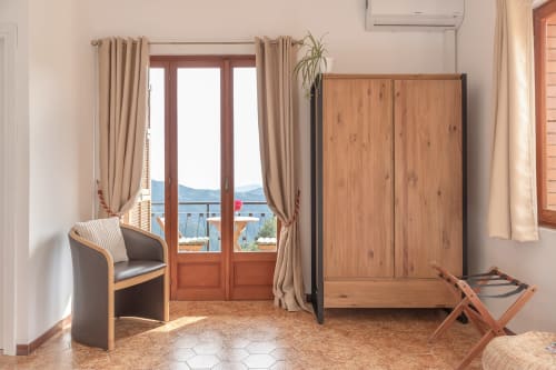 Chambre Gioia de l'hôtel Allegria à Bajardo avec vue montagne, armoire en bois et portes-fenêtres