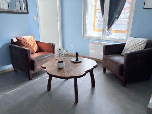 Salon moderne de la Suite Camille Claudel à Au Richebourg Nogent avec fauteuils en cuir et table basse organique