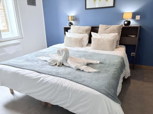 Chambre Suite Camille Claudel à Au Richebourg Nogent, Nogent-sur-Seine, avec mur d'accent bleu et literie blanche