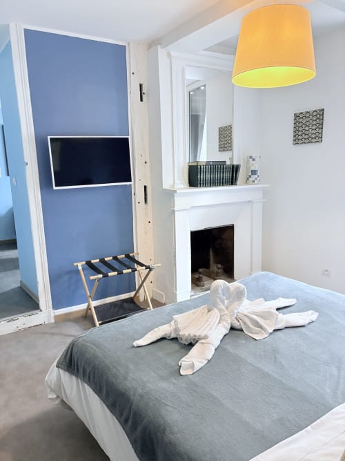 Suite Camille Claudel à Au Richebourg Nogent avec lit, cheminée et mur d'accent bleu