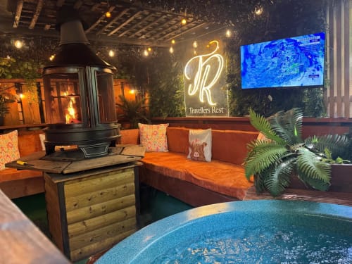 Travellers Rest villa at Four Seasons Glamping Preston with hot tub, fireplace, orange seating and lake view on screen