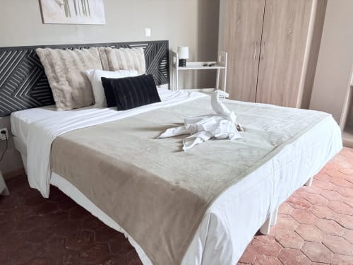 Chambre moderne d'hôtel avec lit king size, linge beige et coussins décor à l'Au Richebourg Nogent, Nogent-sur-Seine