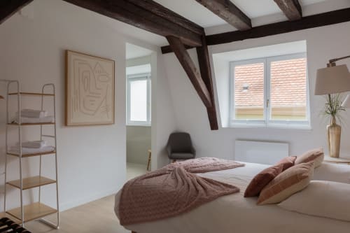 Modern bedroom in Le JO·LIE Duplex, Colmar featuring exposed beams, large windows, and contemporary furnishings
