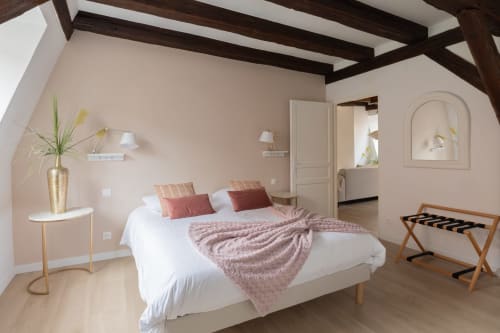 Spacious bedroom at Le JO·LIE Duplex in Colmar with exposed beams, pink walls, white bed, and modern furnishings
