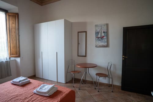 Spaziosa camera da letto presso Casa di Alfredo B&B a Siena con armadio bianco, letti gemelli, tavolino e quadro con barca a vela