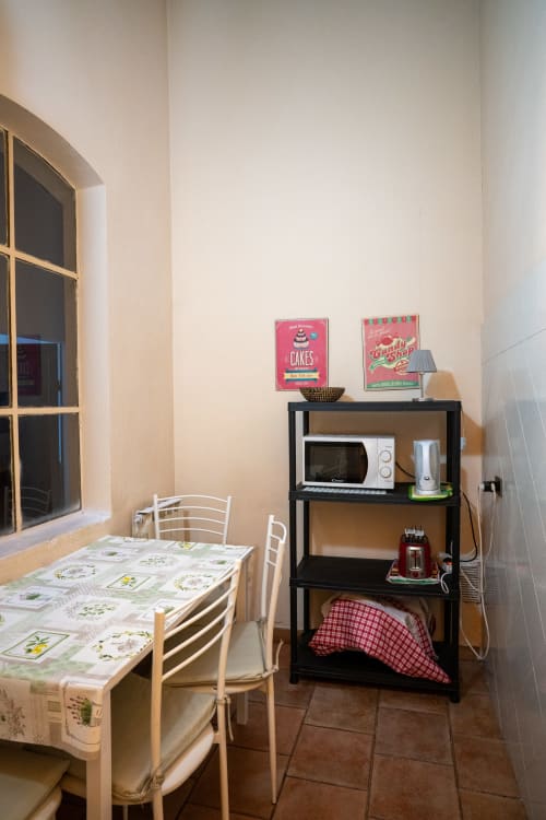 Accogliente angolo cucina presso il B&B Casa di Alfredo a Siena con tavolo da pranzo, scaffali neri e poster vintage