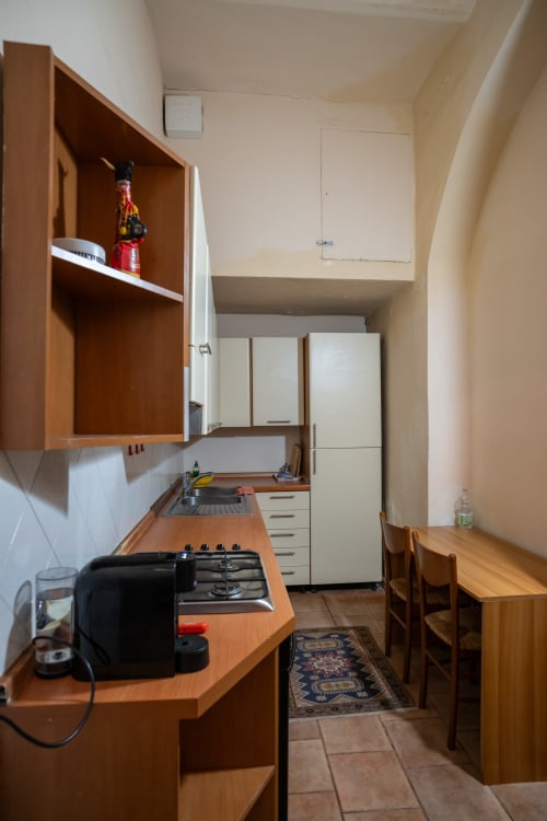 Cucina compatta nella Casa di Alfredo a Siena, con mobili in legno, fornello a gas e zona pranzo