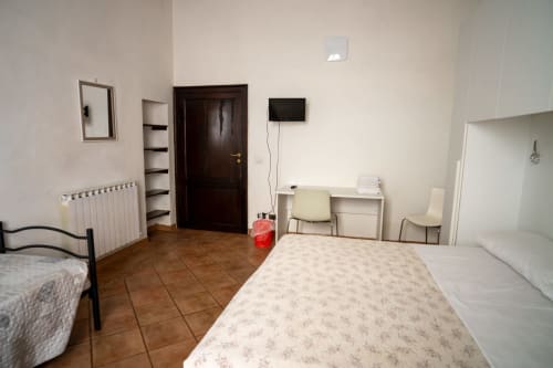 Spaziosa camera tripla a Casa di Alfardo B&B a Siena con due letti, scrivania, TV e pavimenti piastrellati