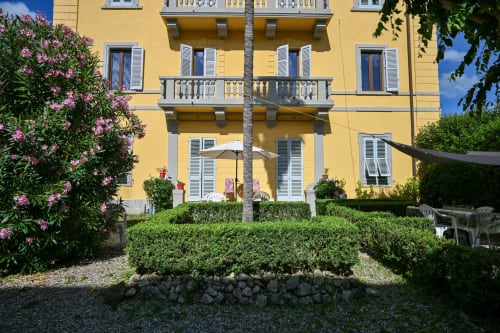 Affascinante villa gialla Casa di Alfredo a Siena con fiori in fiore, siepi curate e finestre con persiane bianche