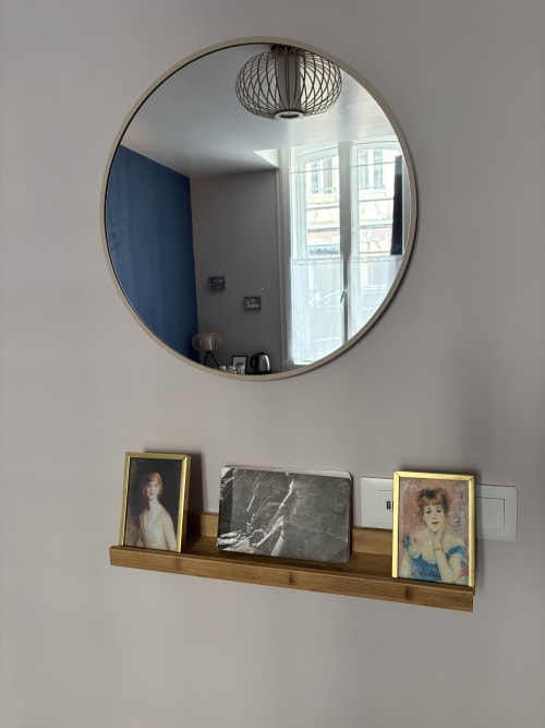 Miroir rond au-dessus d'une étagère en bois avec portraits encadrés dans la Suite Gustave Flaubert à l'Au Richebourg Nogent, Nogent-sur-Seine