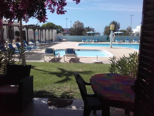 Terraço da Albufeira Inn com vista para piscinas, espreguiçadeiras e jardim bem cuidado em Portugal